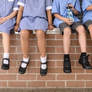 Children sat on a wall at school
